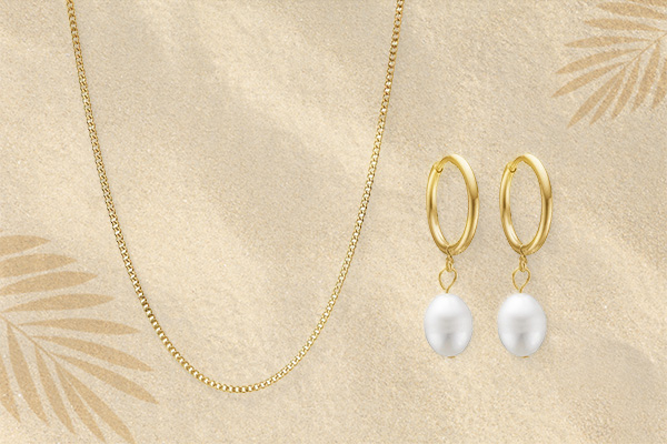 Jewellery laying in the beach sand in a summer sale theme